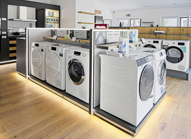 Innenansicht des Ausstellungsraums von Hausgeräte Schmid. Mehrere Waschmaschinen und Wäschetrockner.